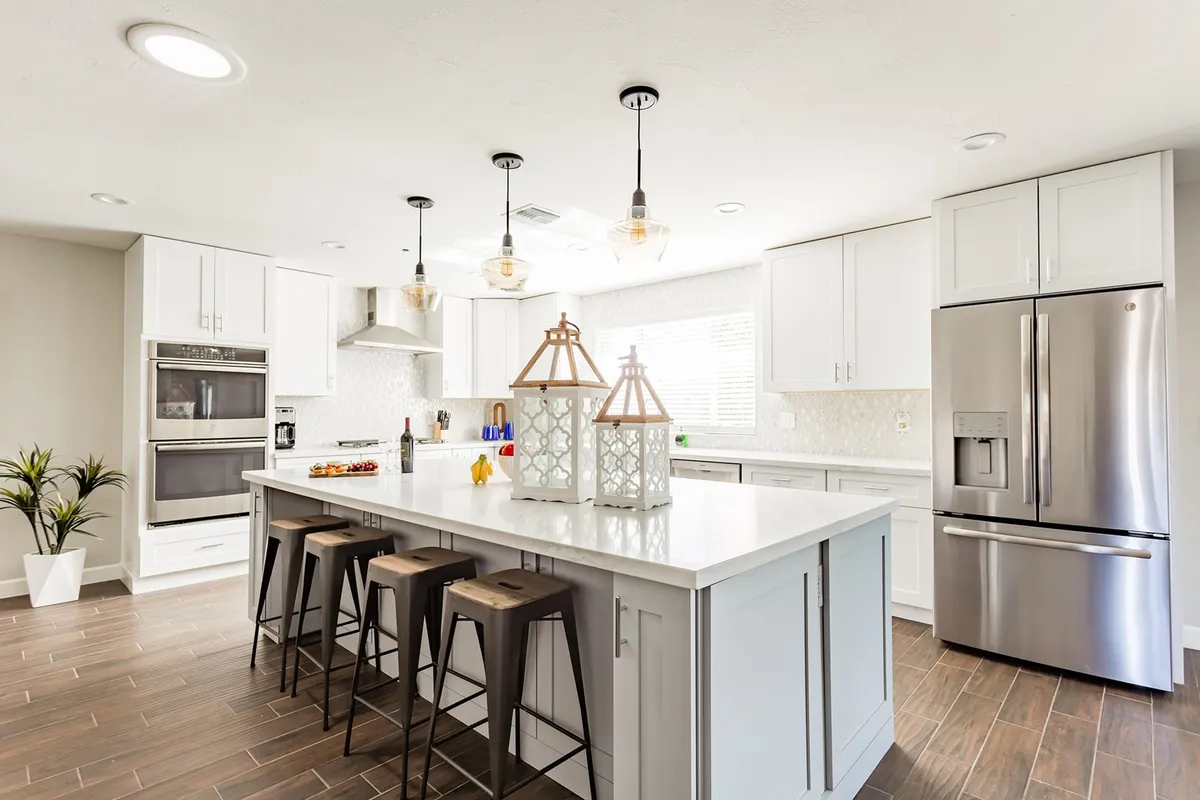 A modern kitchen with a central island, sleek pendant lighting, up-to-date appliances, and decorative touches. The kitchen is both stylish and functional, ready for preparing meals or socializing.